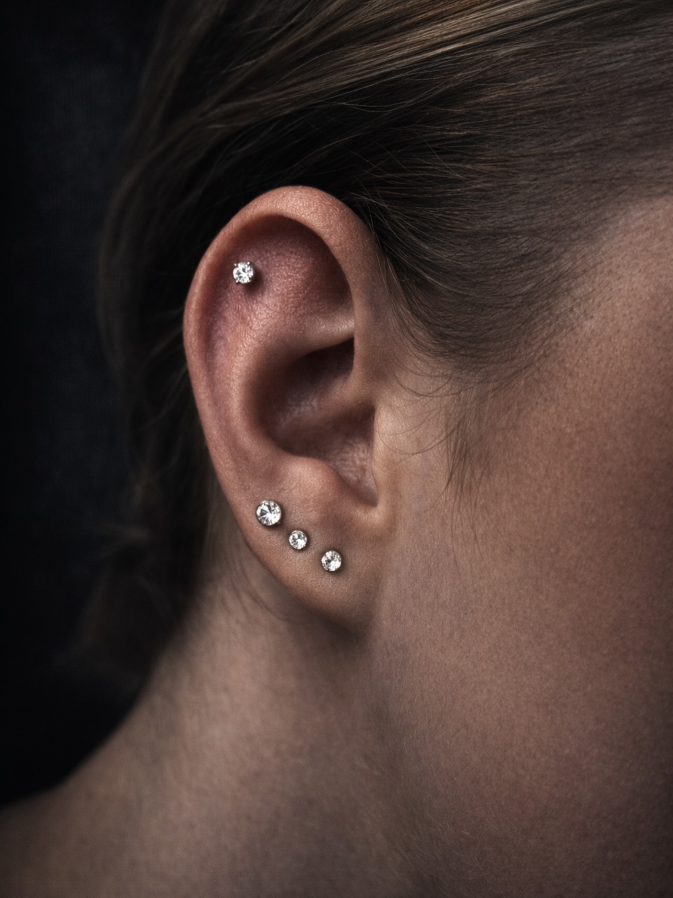 Piercing ucha — helix i płatek z delikatną biżuterią